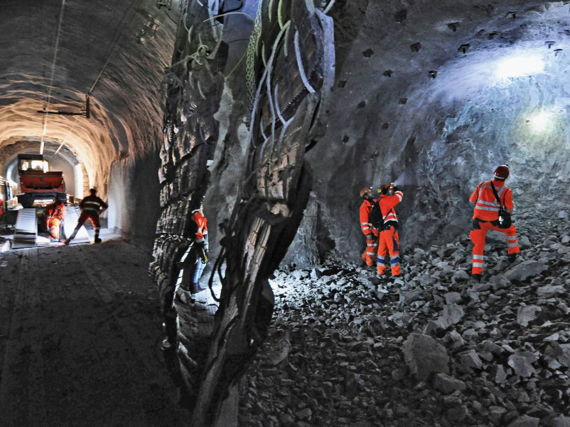 Photo: chantier du tunnel avec machines de construction et ouvriers avec tenues de protection
